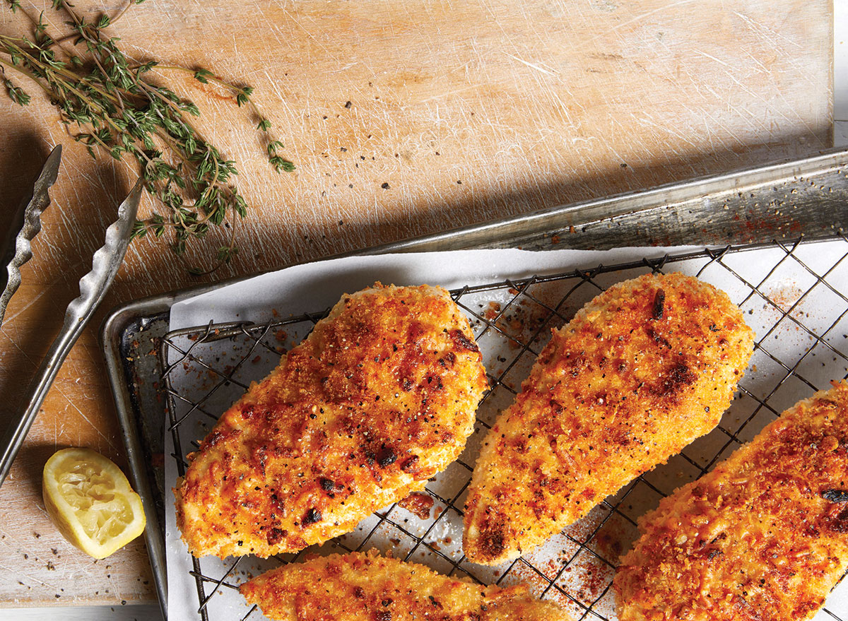 crispy chicken on pan with tongs and lemon